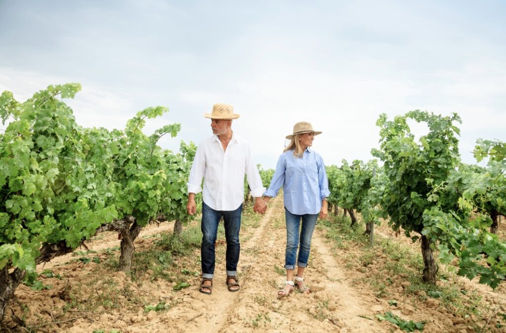 senior couple walking through a vineyard