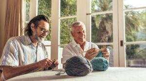 two seniors learning how to knit together